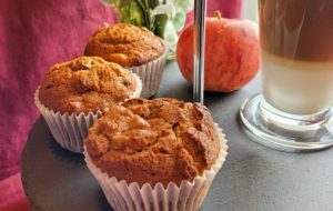 Picture of apple, cinnamon and maple muffins on a cake stand with a cup of coffee.