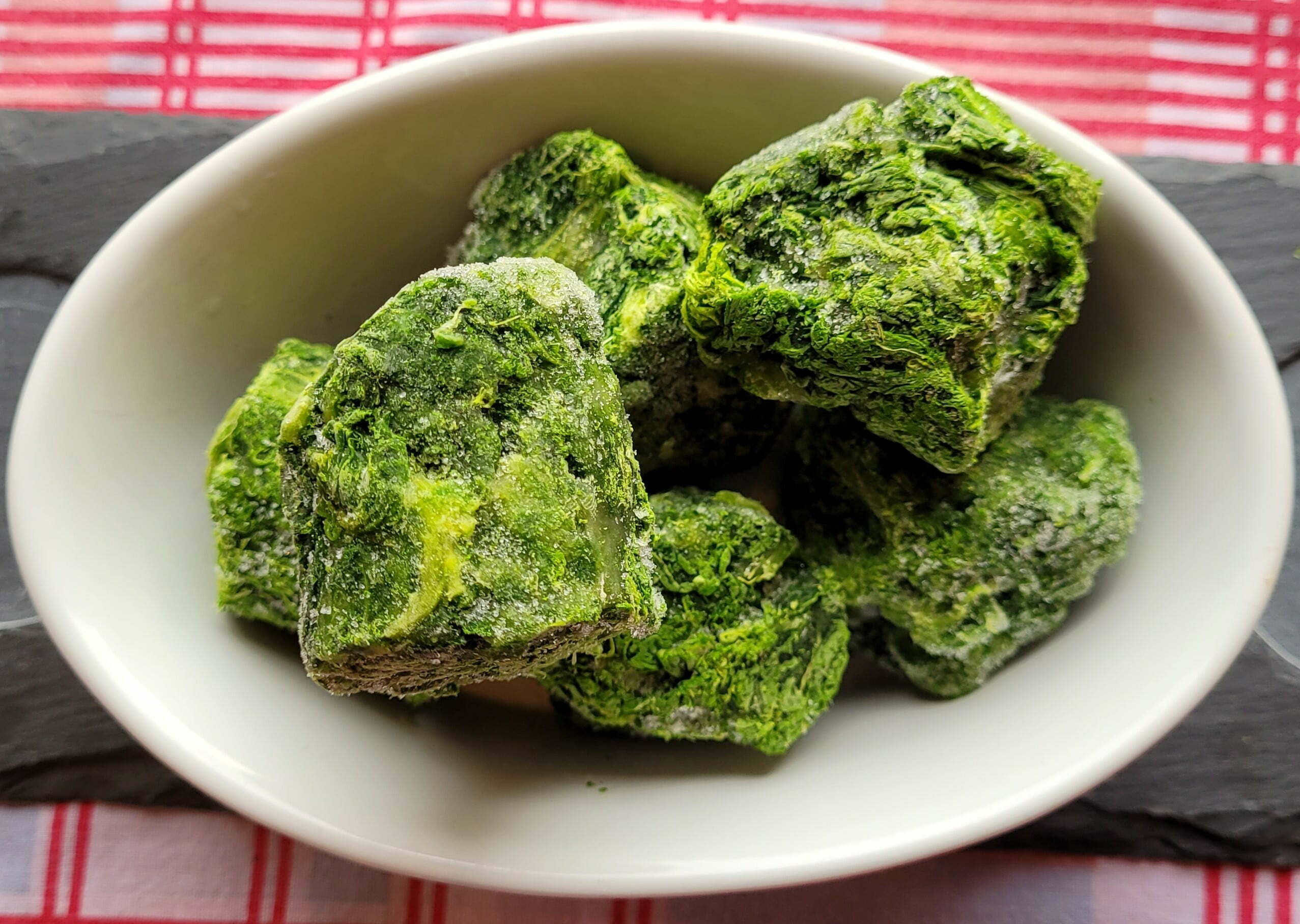 A bowl of frozen spinach pieces